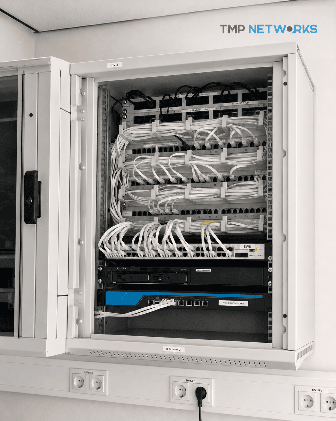 Netzwerkschrank mit moderner Netzwerkhardware und TMP Networks Logo